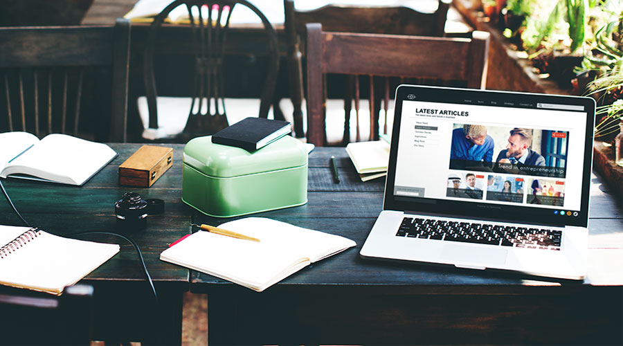 A laptop showing a website's latest articles page