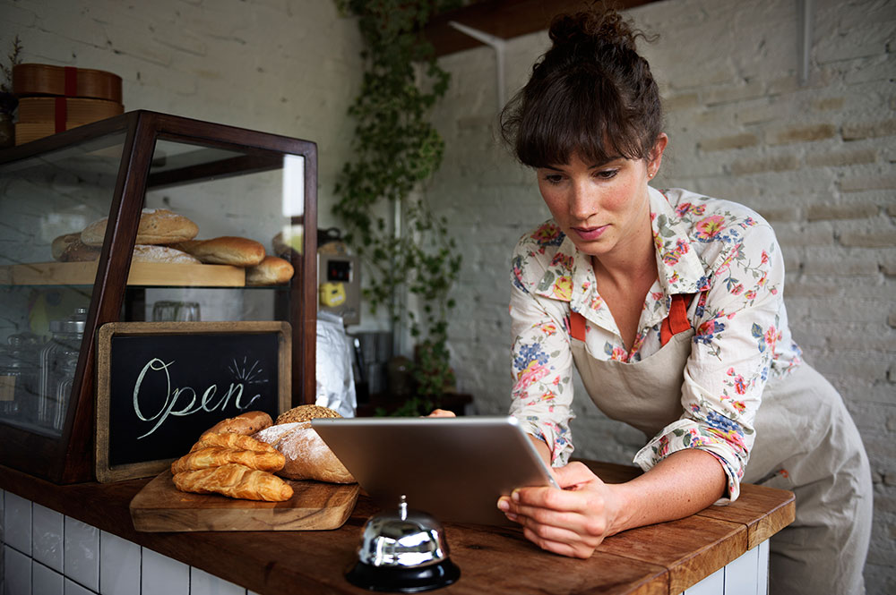 A woman on a tablet looking at her small business website
