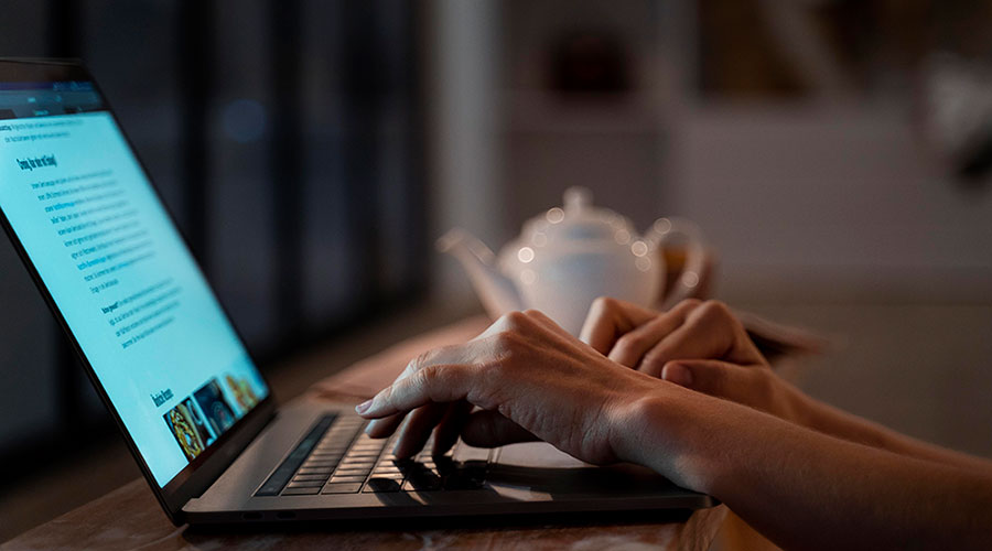A person writing content on a laptop