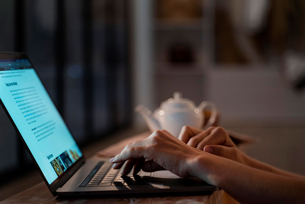 A person writing content on a laptop