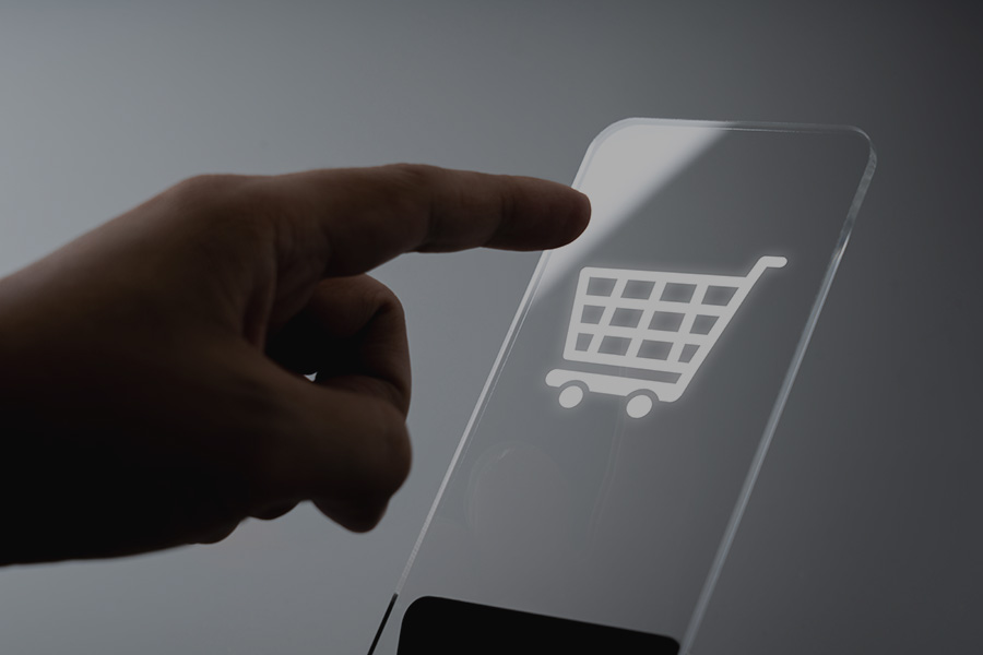 A person touching an image of a shopping cart on their mobile phone