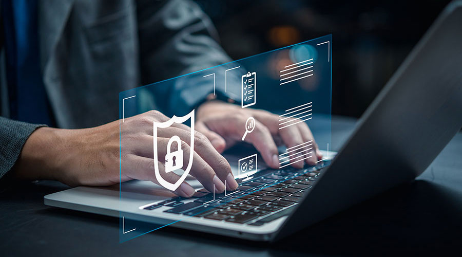 A person sat at a laptop with security and maintenance icons hovering over the keyboard