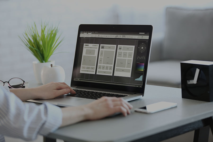 A person sat at a laptop designing a website