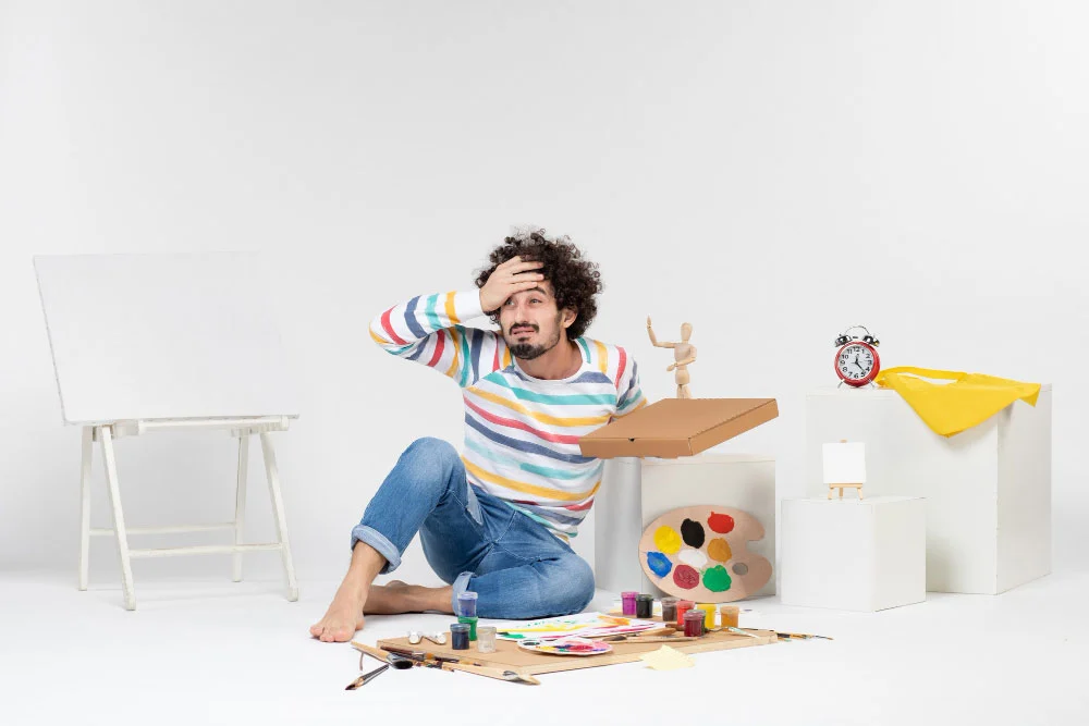 A frustrated man having to paint something he doesn't know how to