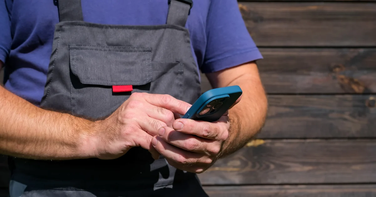 A tradesman checking the local SEO cost for his business on his phone